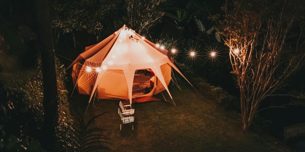 glamping party in a forest with fairy lights and tents