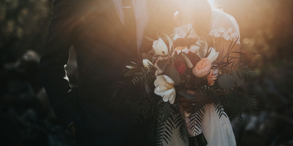 groom beside bride holding bouquet flowers